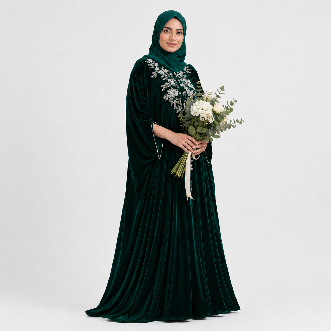 Woman in a dark green abaya holding flowers on a white background