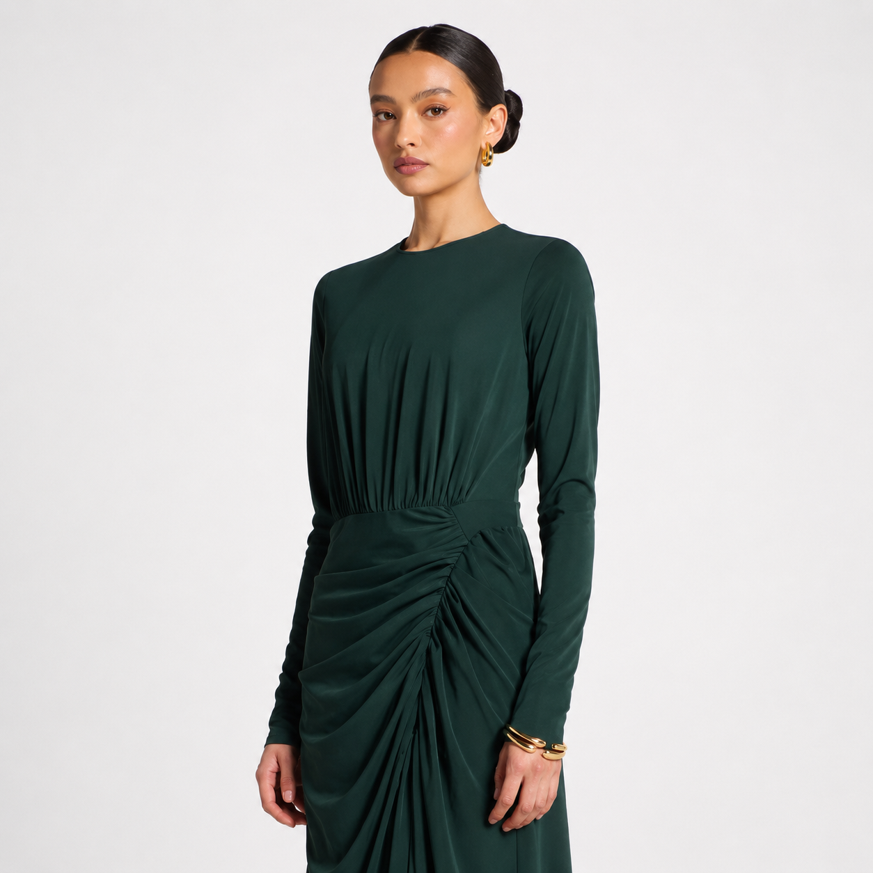 Woman wearing a green dress with a plain background