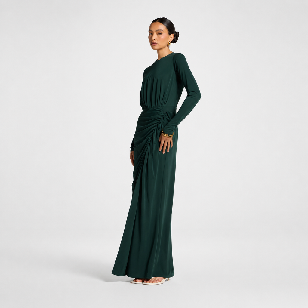 Woman wearing a dark green long-sleeve dress on a white background
