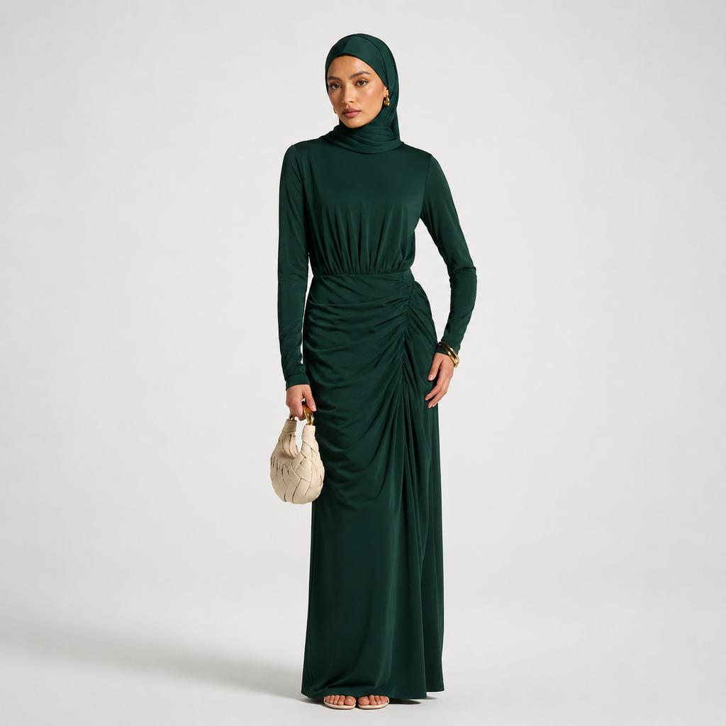 Woman wearing a green long-sleeve dress with a matching hijab on a white background