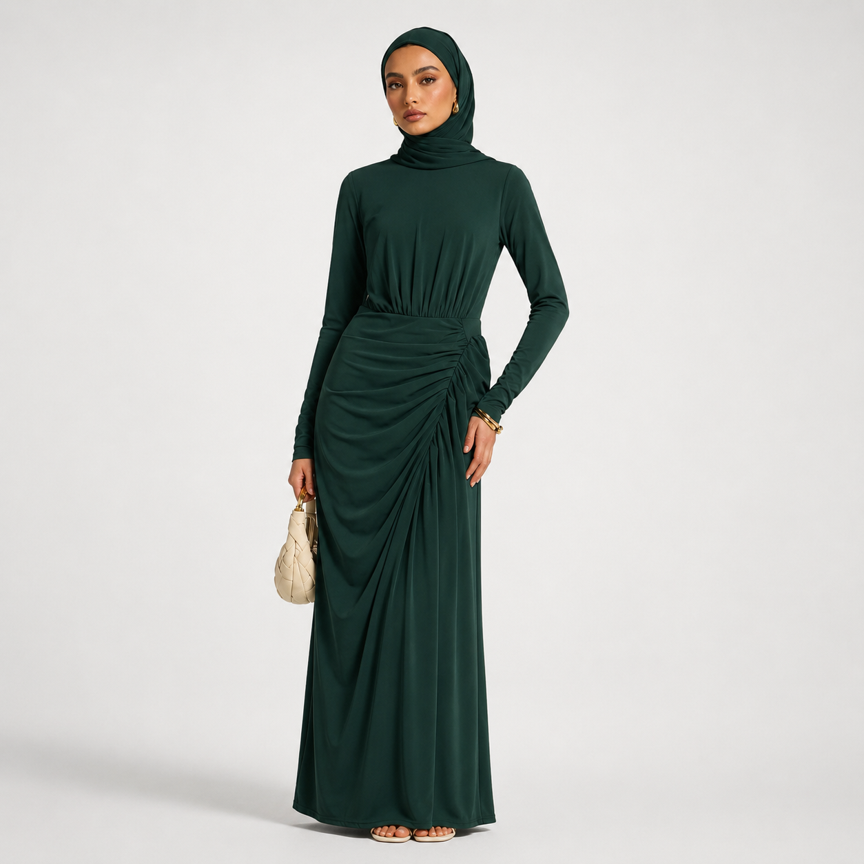 Woman wearing a dark green long-sleeve dress with a hood on a white background