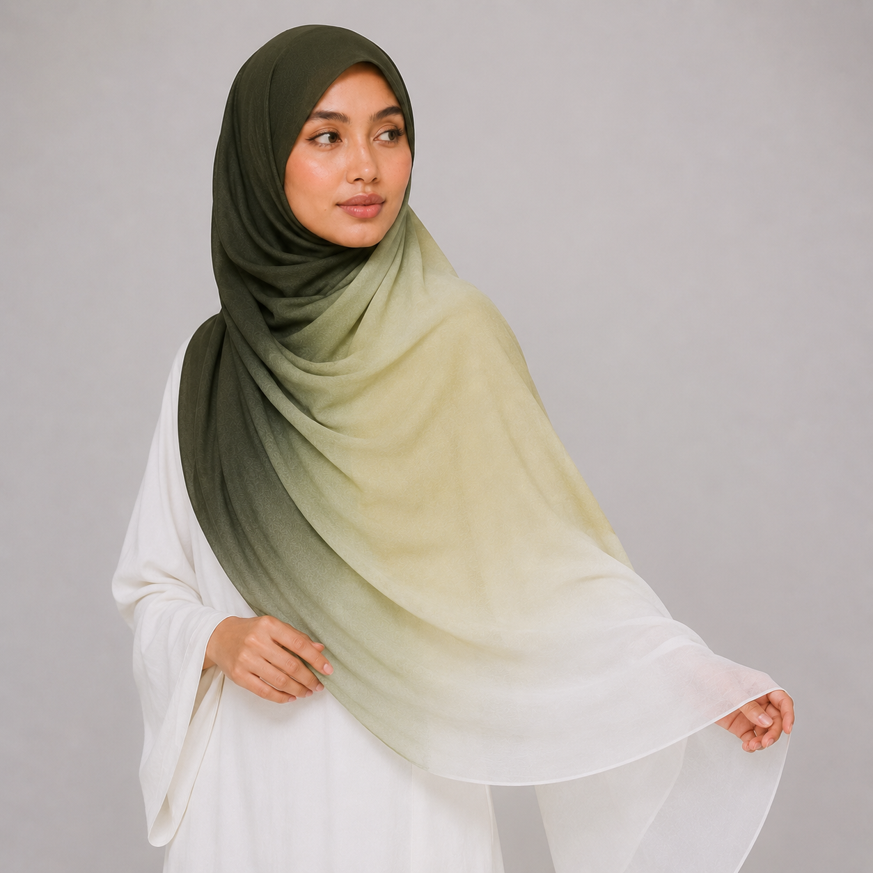 Woman wearing a green to beige gradient hijab against a gray background
