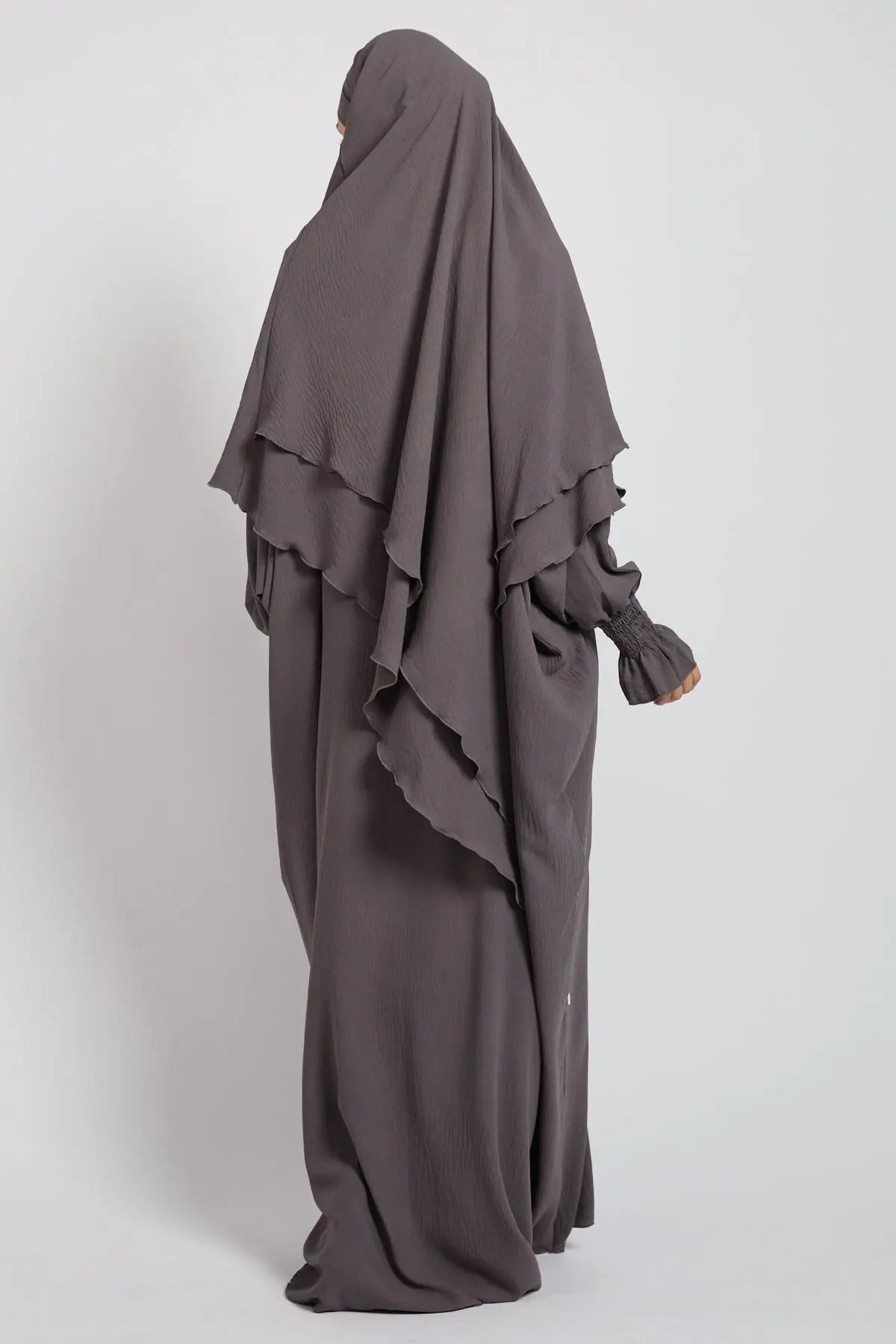 Long dark gray dress with a hood on a white background