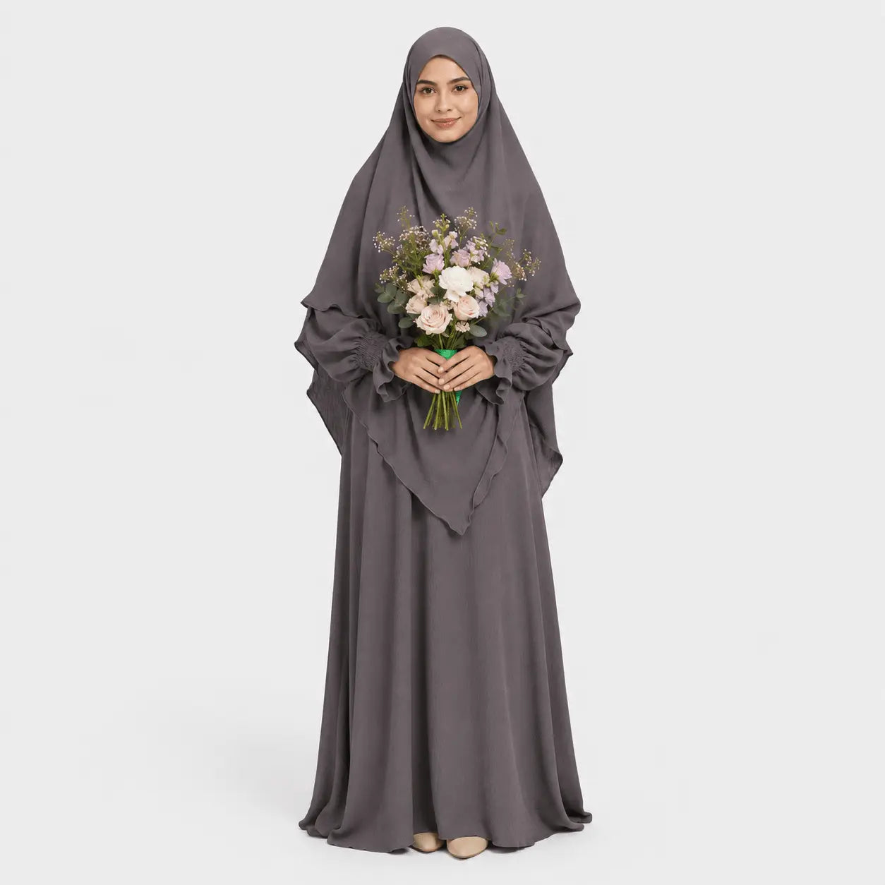 Woman wearing a gray abaya holding flowers on a white background
