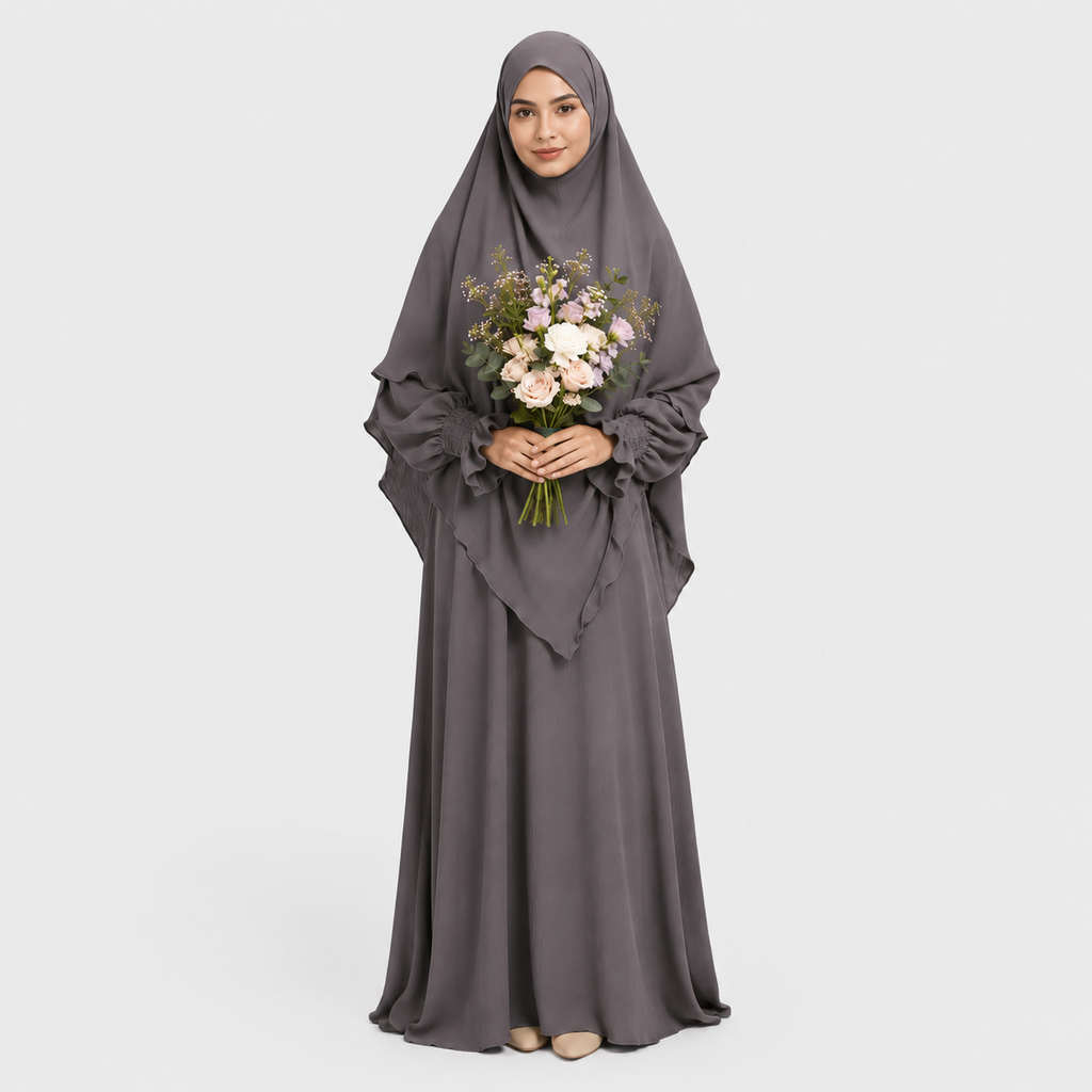 Woman in a long gray dress holding flowers on a white background