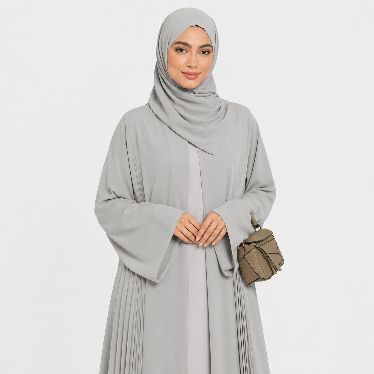 Woman wearing a light gray abaya with a matching hijab on a white background