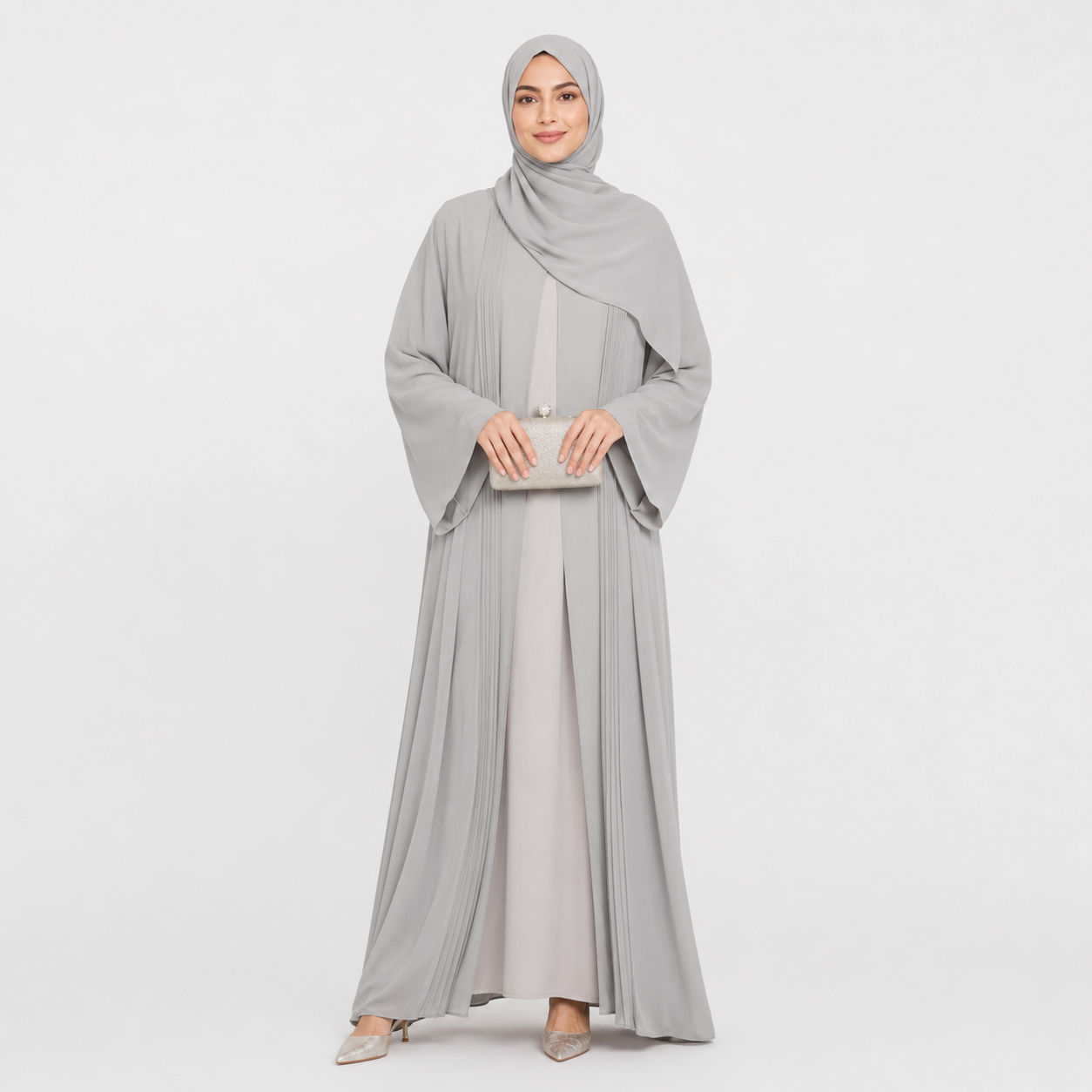 Woman wearing a gray abaya and hijab on a white background