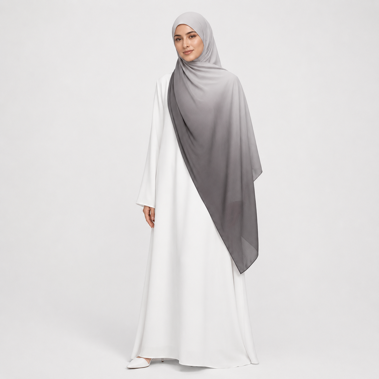 Woman wearing a white dress with a gray hijab on a light gray background