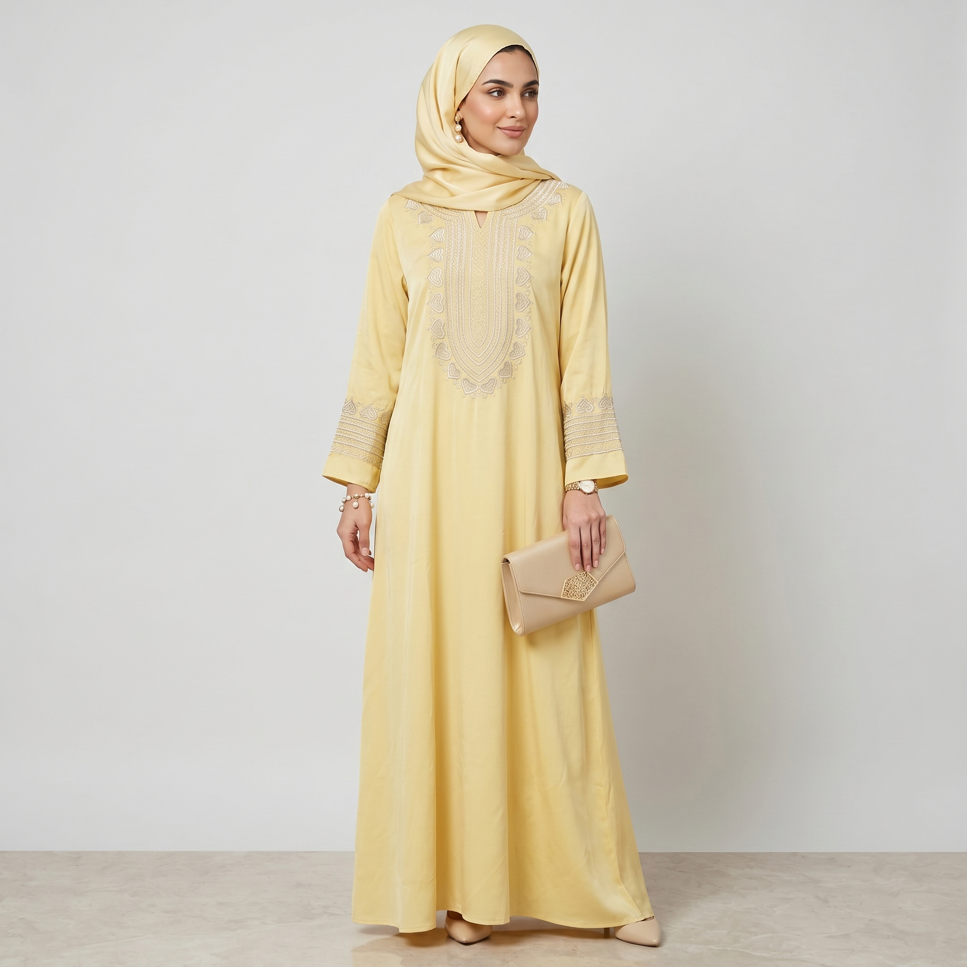 Woman wearing a yellow dress with beige embroidery on a white background
