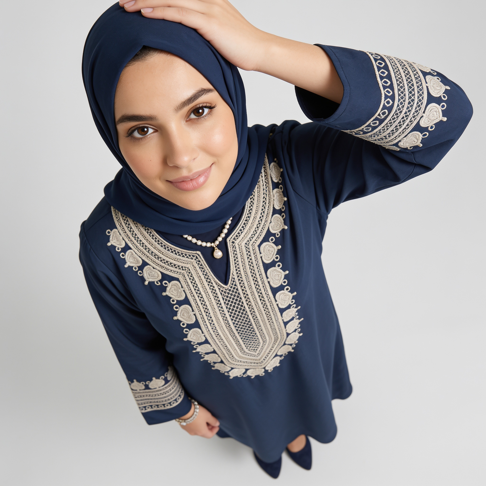 Navy blue dress with intricate white embroidery on a plain background