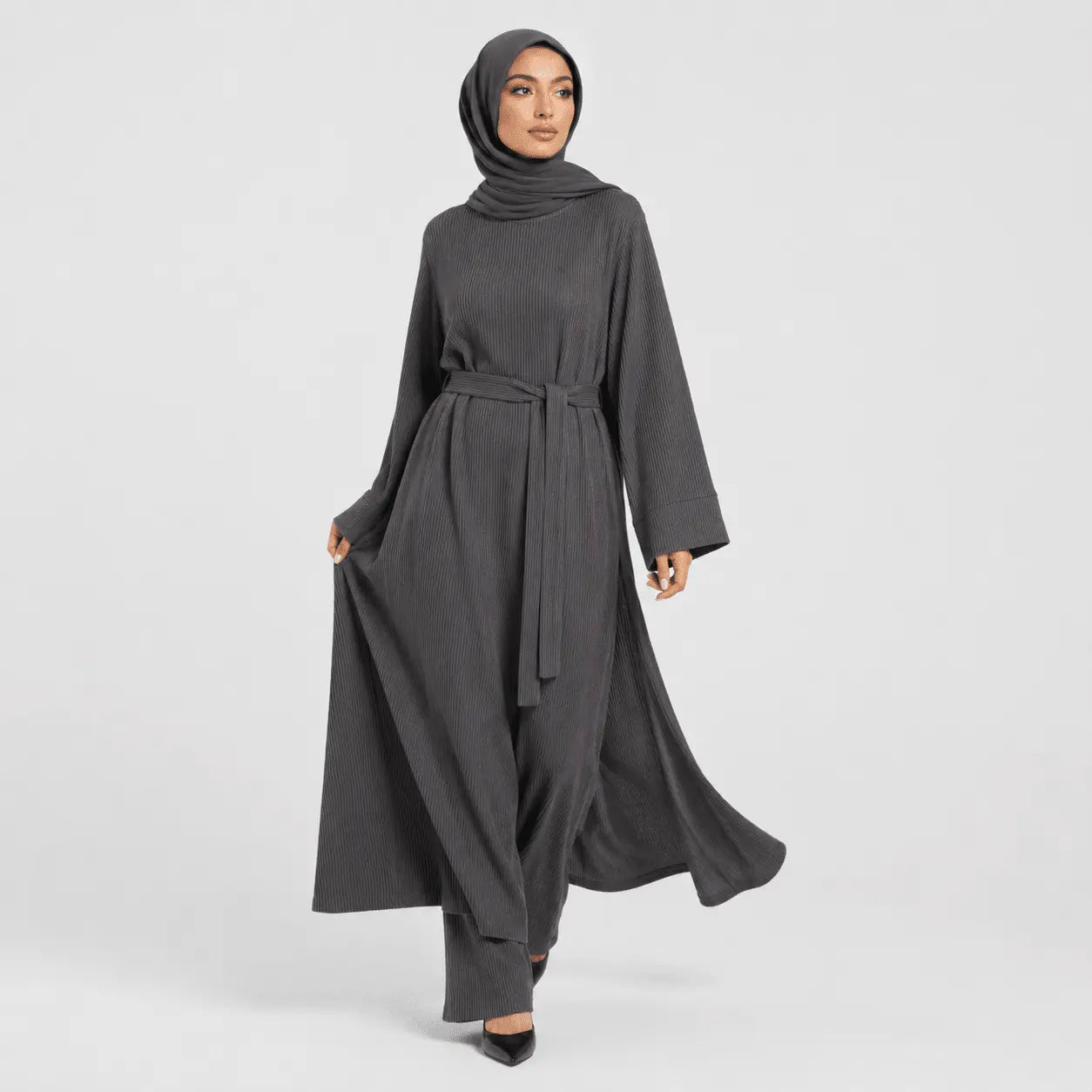 Woman wearing a gray abaya on a white background