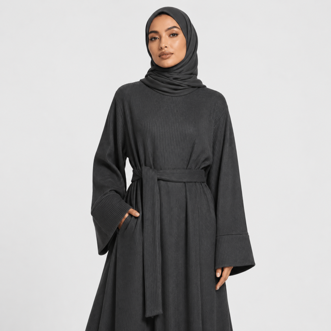 Woman wearing a long dark gray dress on a white background