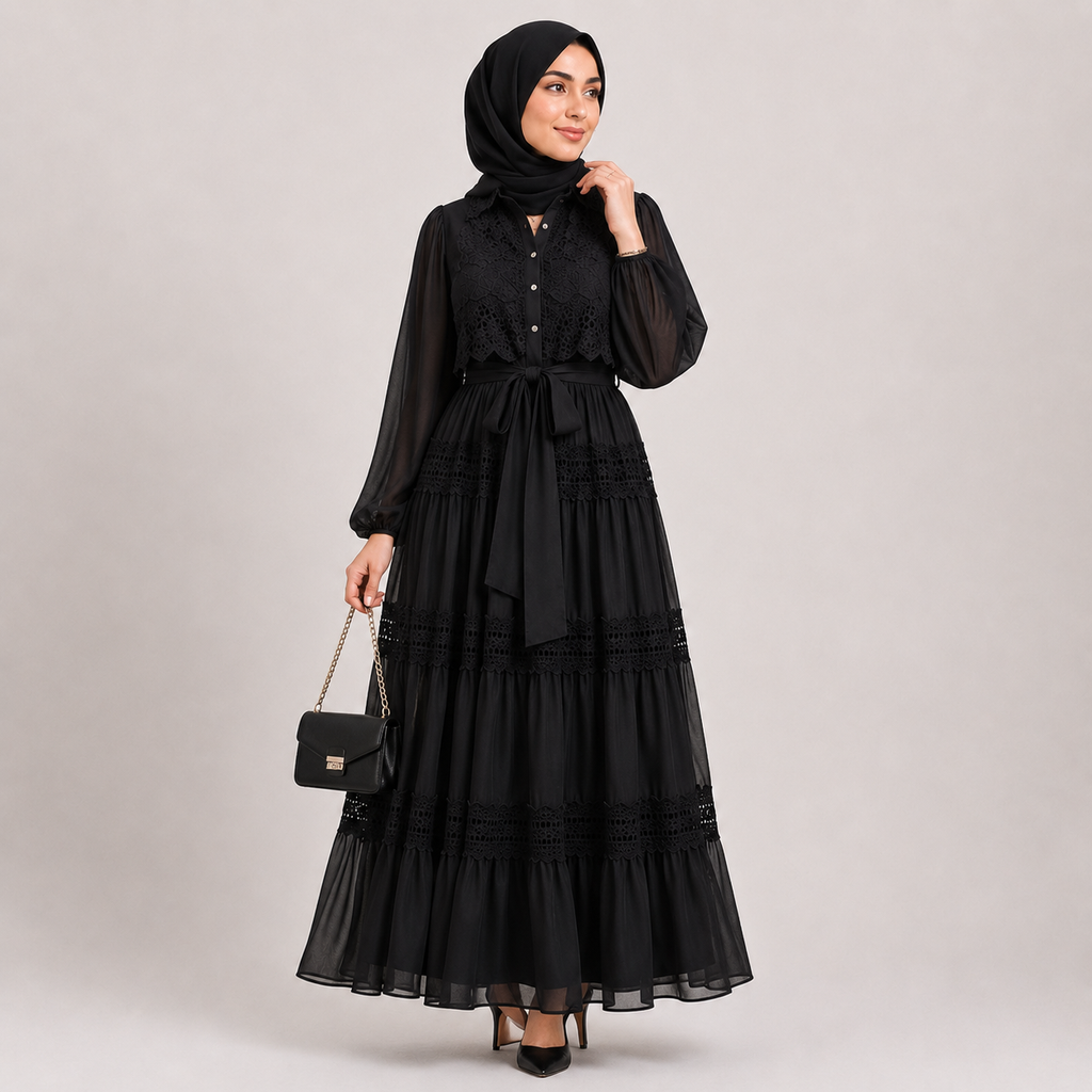 Woman wearing a black dress and hijab on a plain background