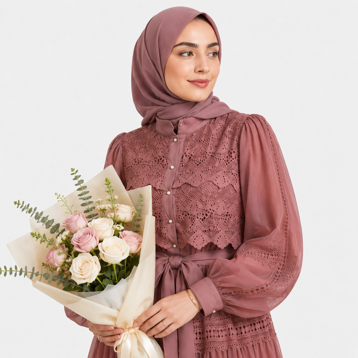 Woman wearing a mauve lace dress and hijab holding a bouquet of flowers on a white background