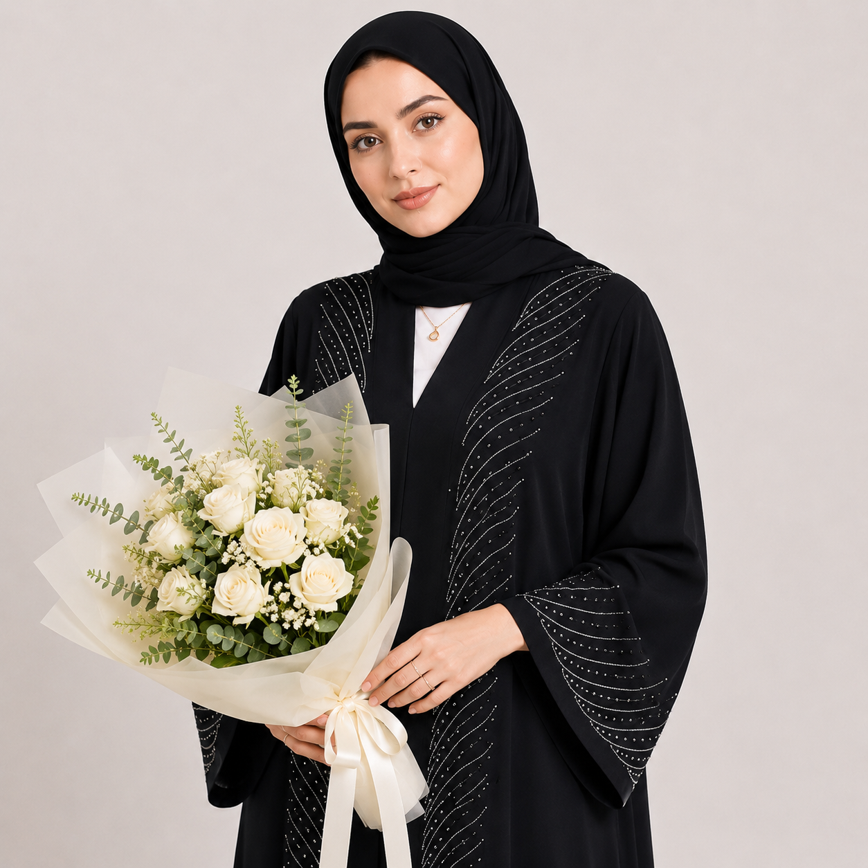 Woman in black abaya holding a bouquet of white roses against a plain background