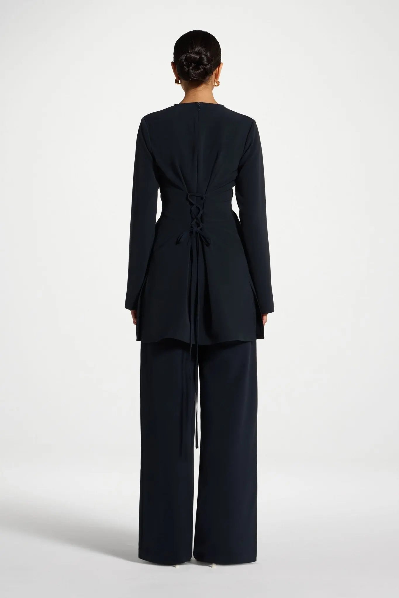 Person wearing a black suit on a white background