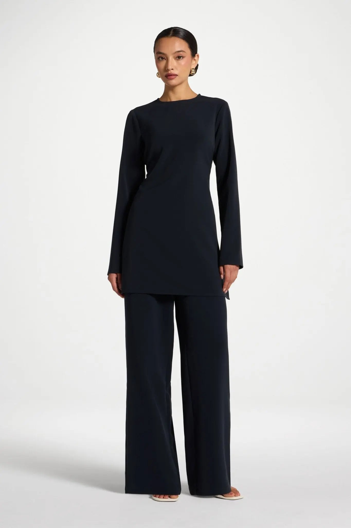 Woman wearing a black outfit on a white background