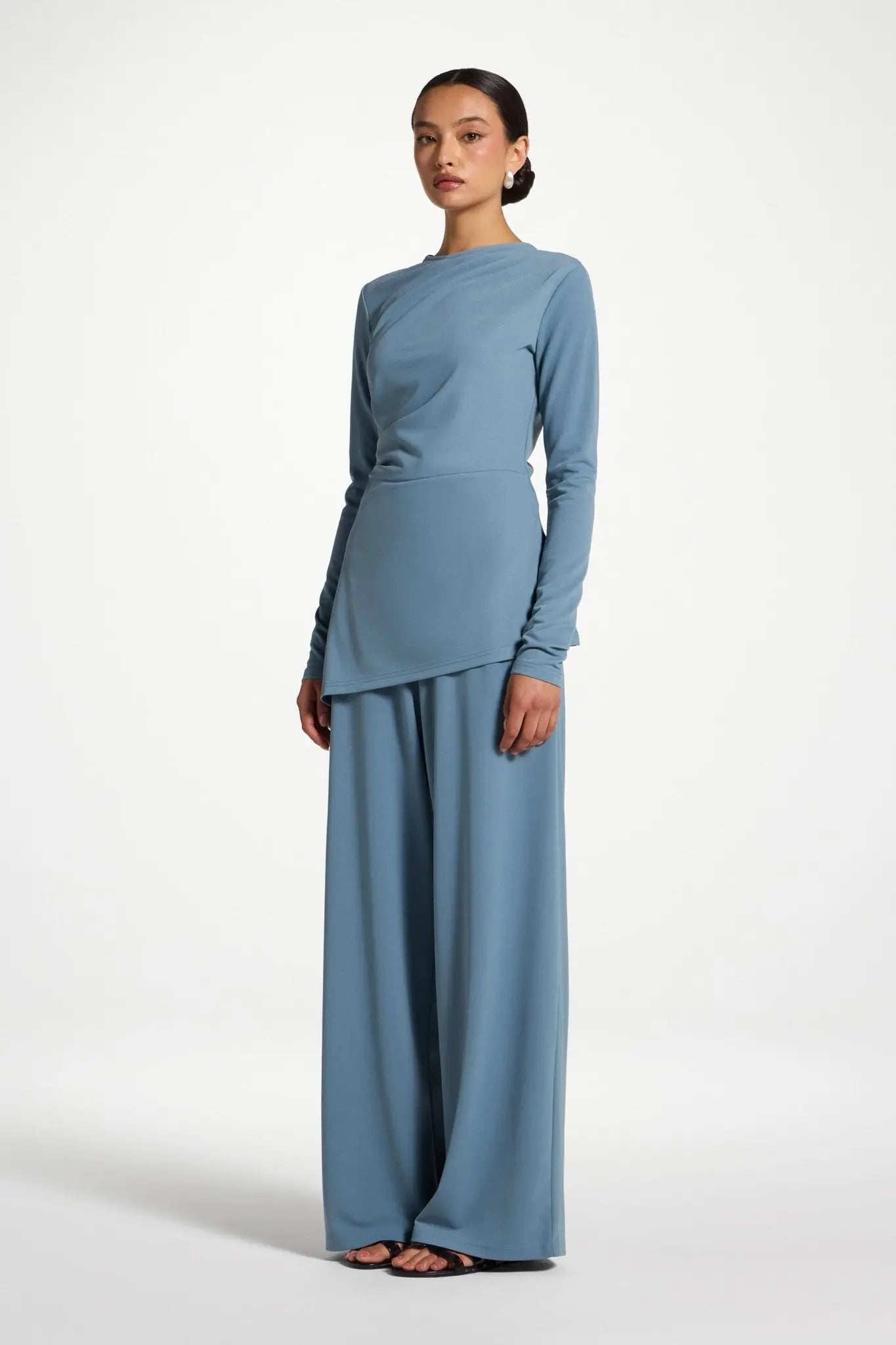 Woman wearing a light blue outfit on a white background