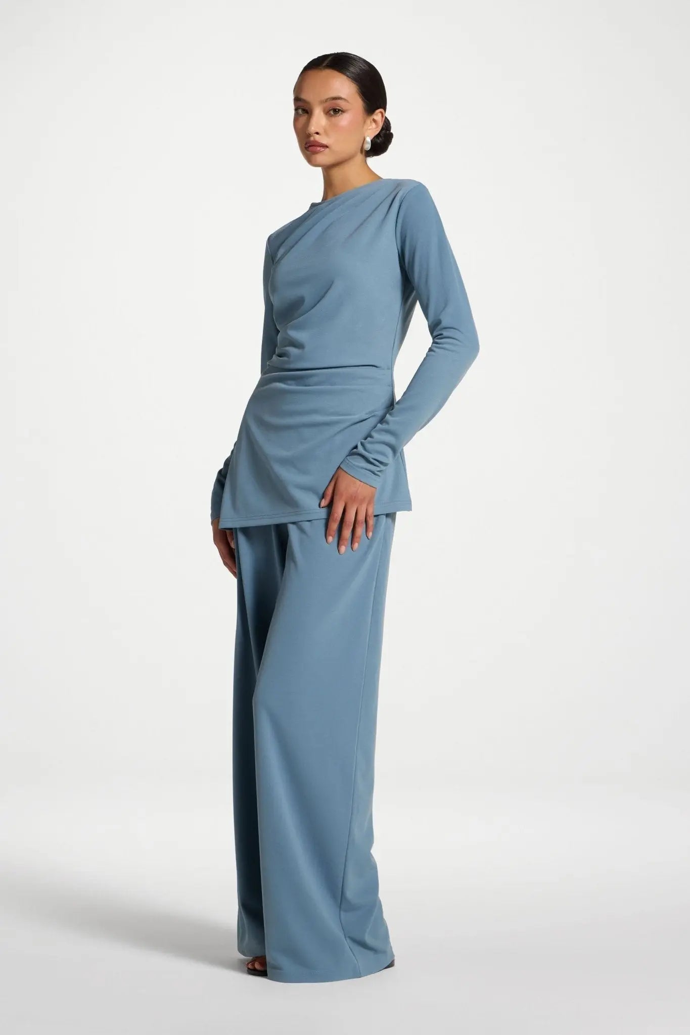 Woman wearing a blue dress with a plain background