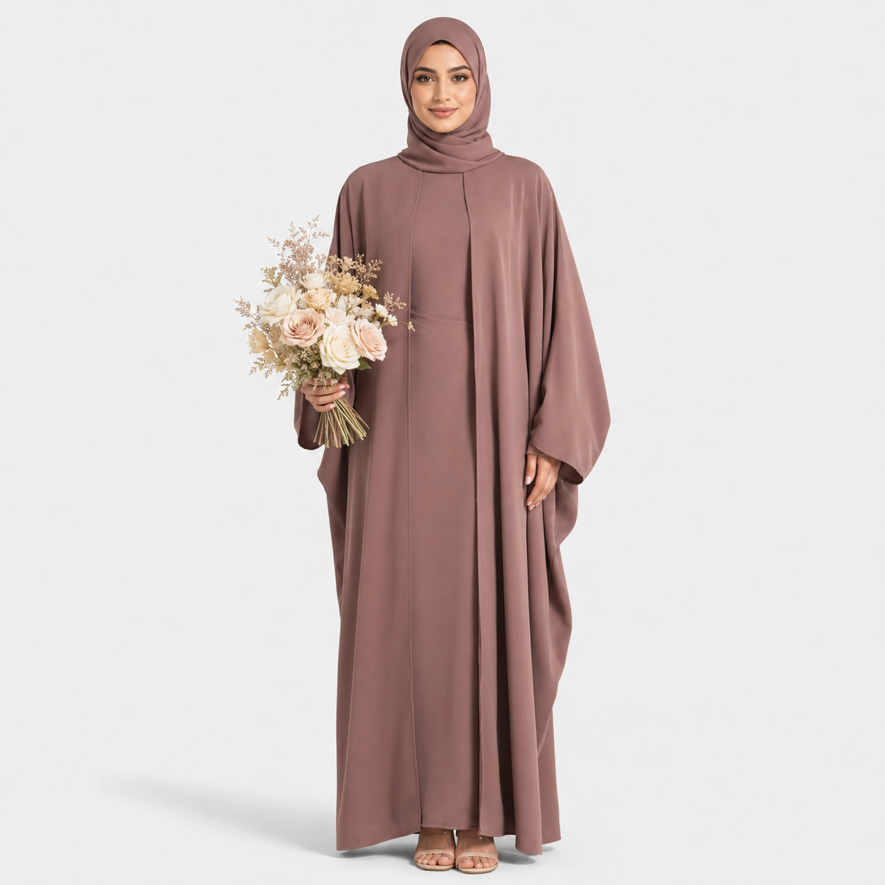 Woman wearing a long brown dress holding flowers on a white background