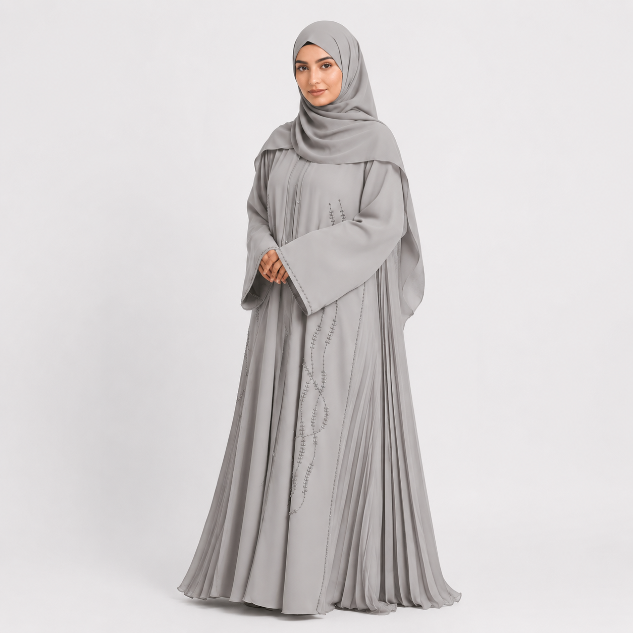 Woman wearing a gray abaya with a matching hijab on a white background