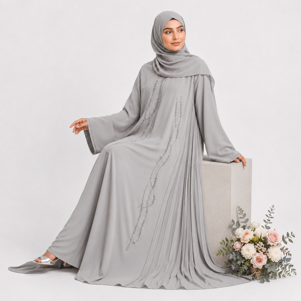 Woman wearing a gray abaya with intricate designs on a white background