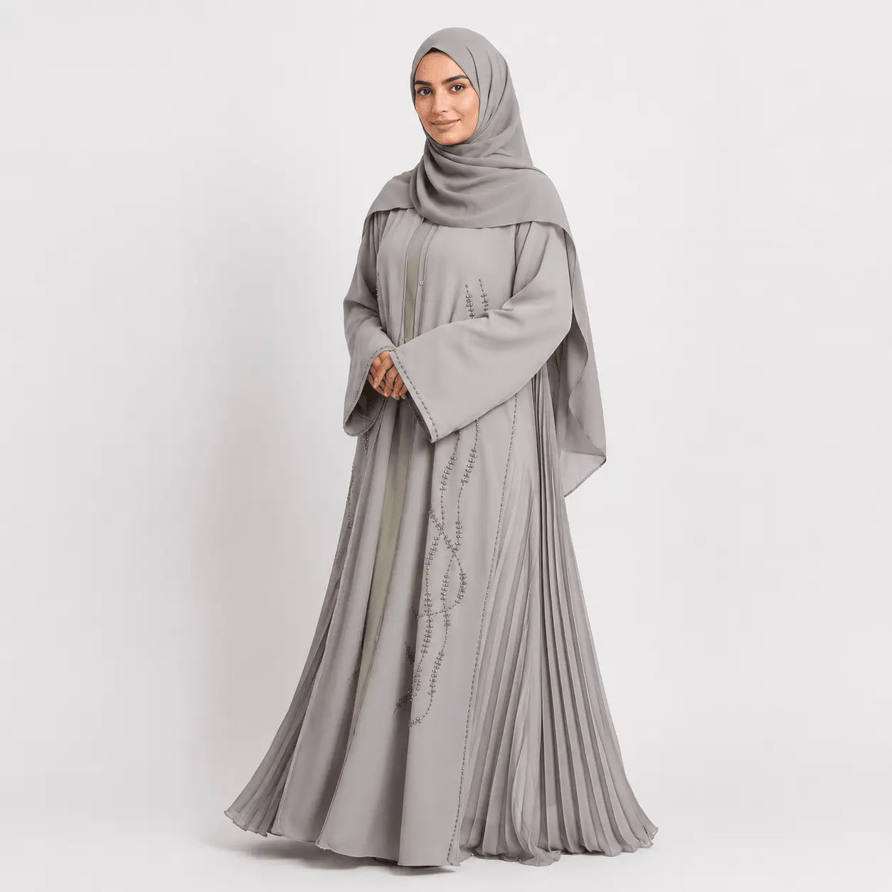 Woman wearing a gray abaya with a matching hijab on a white background