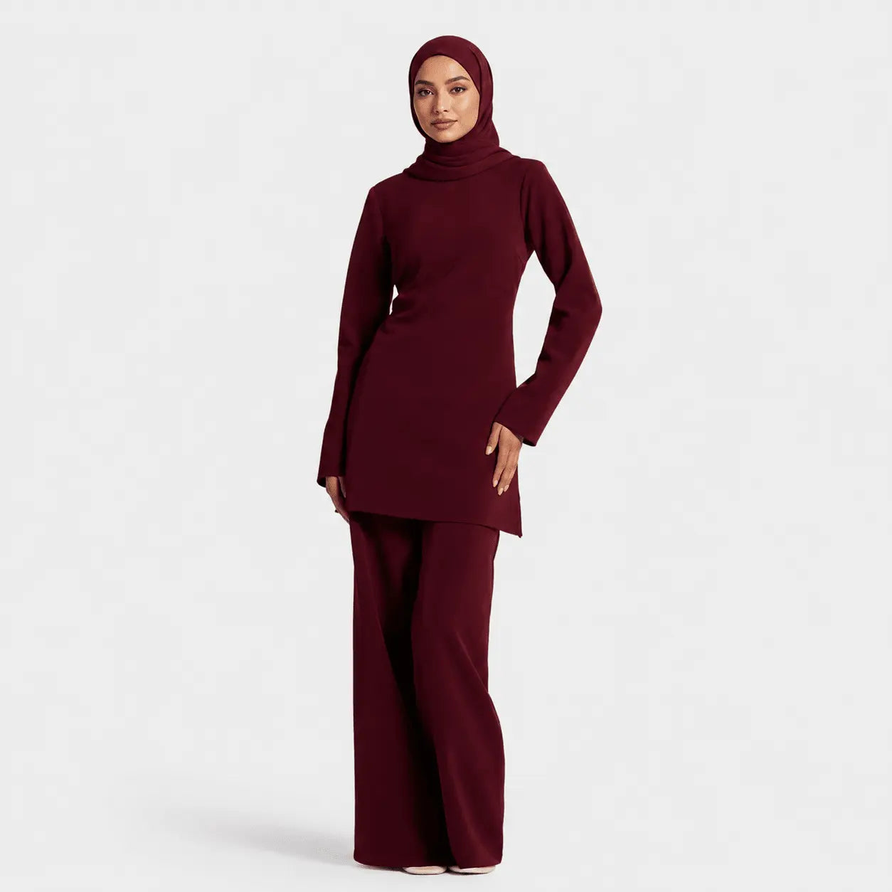 Woman wearing a burgundy outfit on a white background