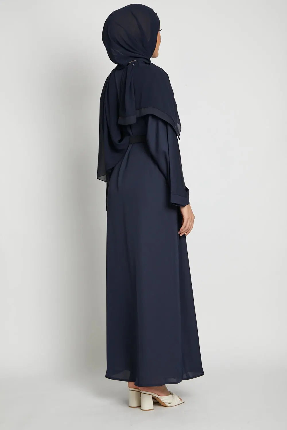 Navy blue abaya worn by a person on a white background