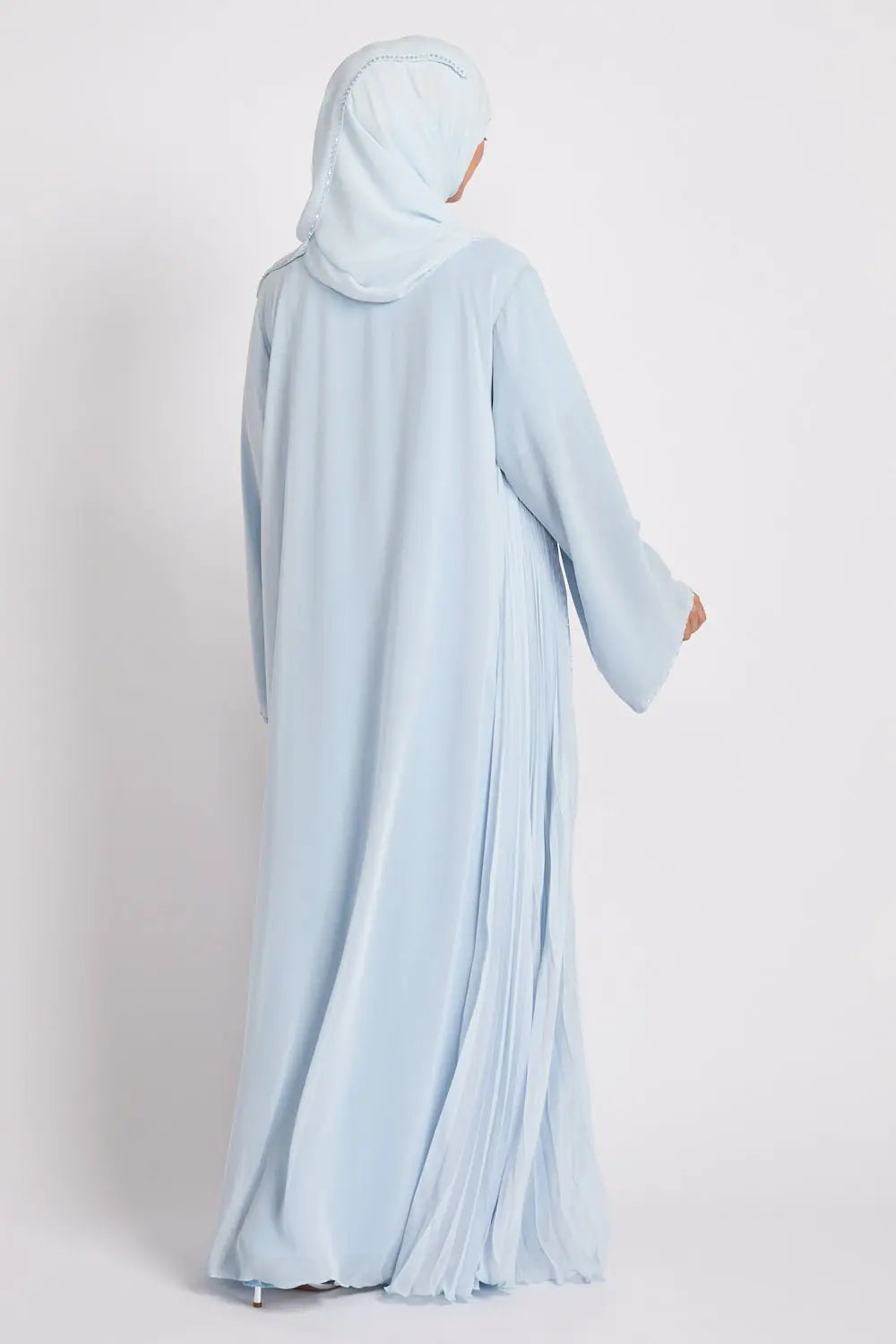 Person wearing a light blue abaya and hijab on a white background