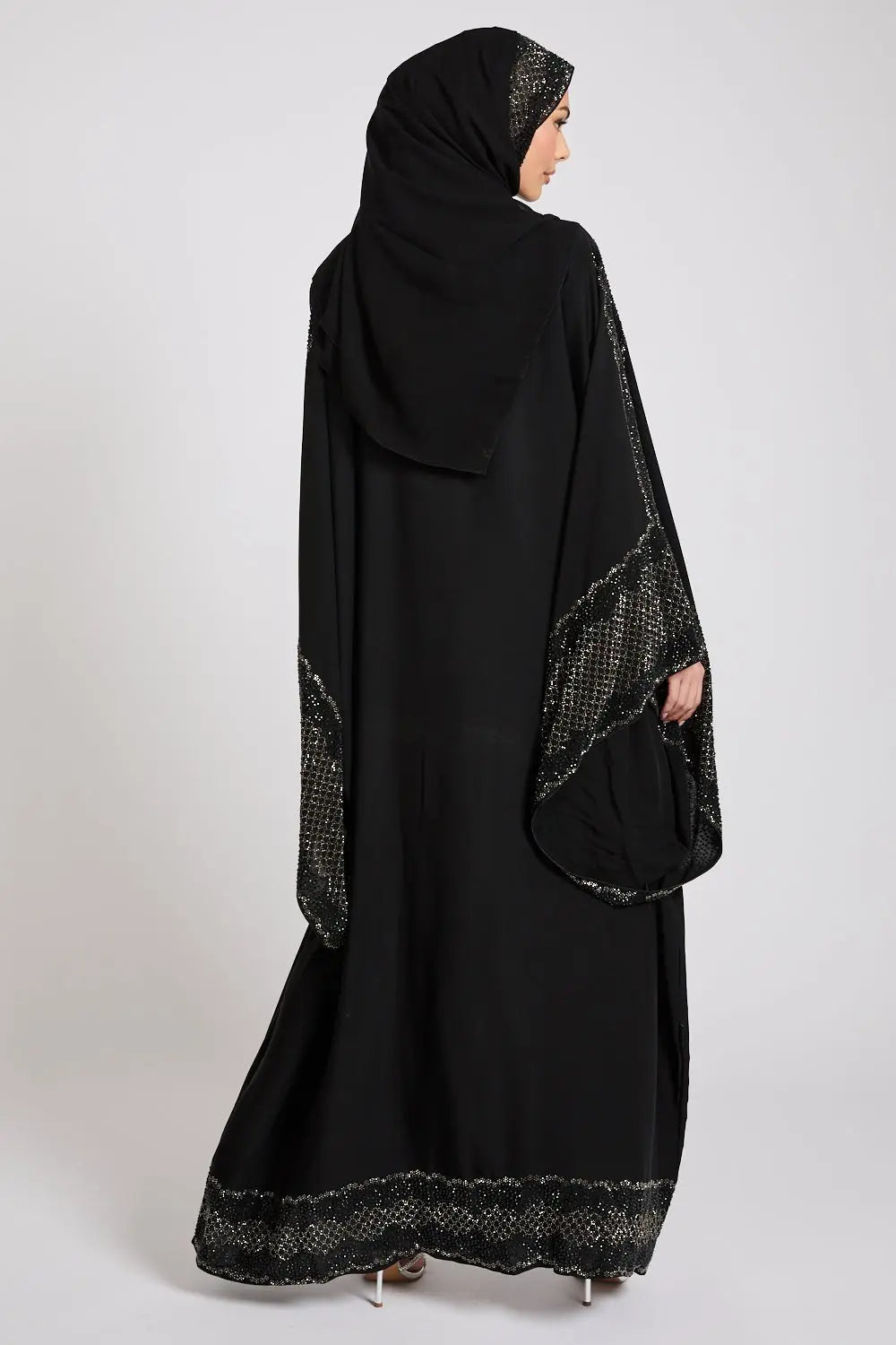Black abaya with intricate detailing on a white background