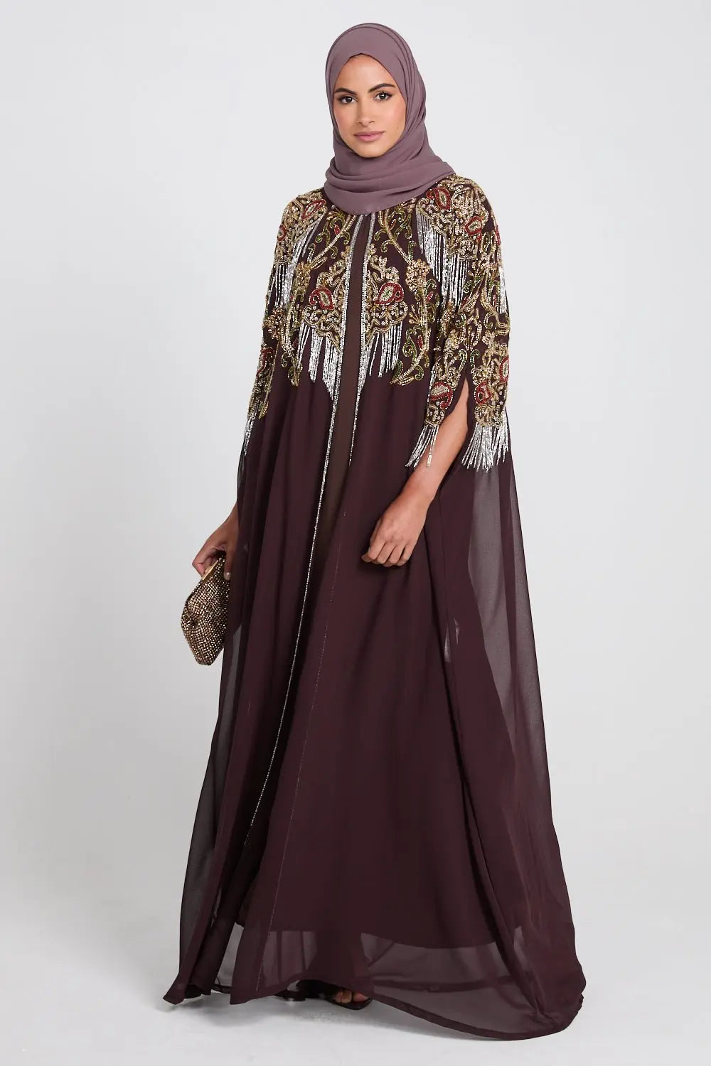 Woman wearing a dark brown dress with embroidered sleeves on a white background
