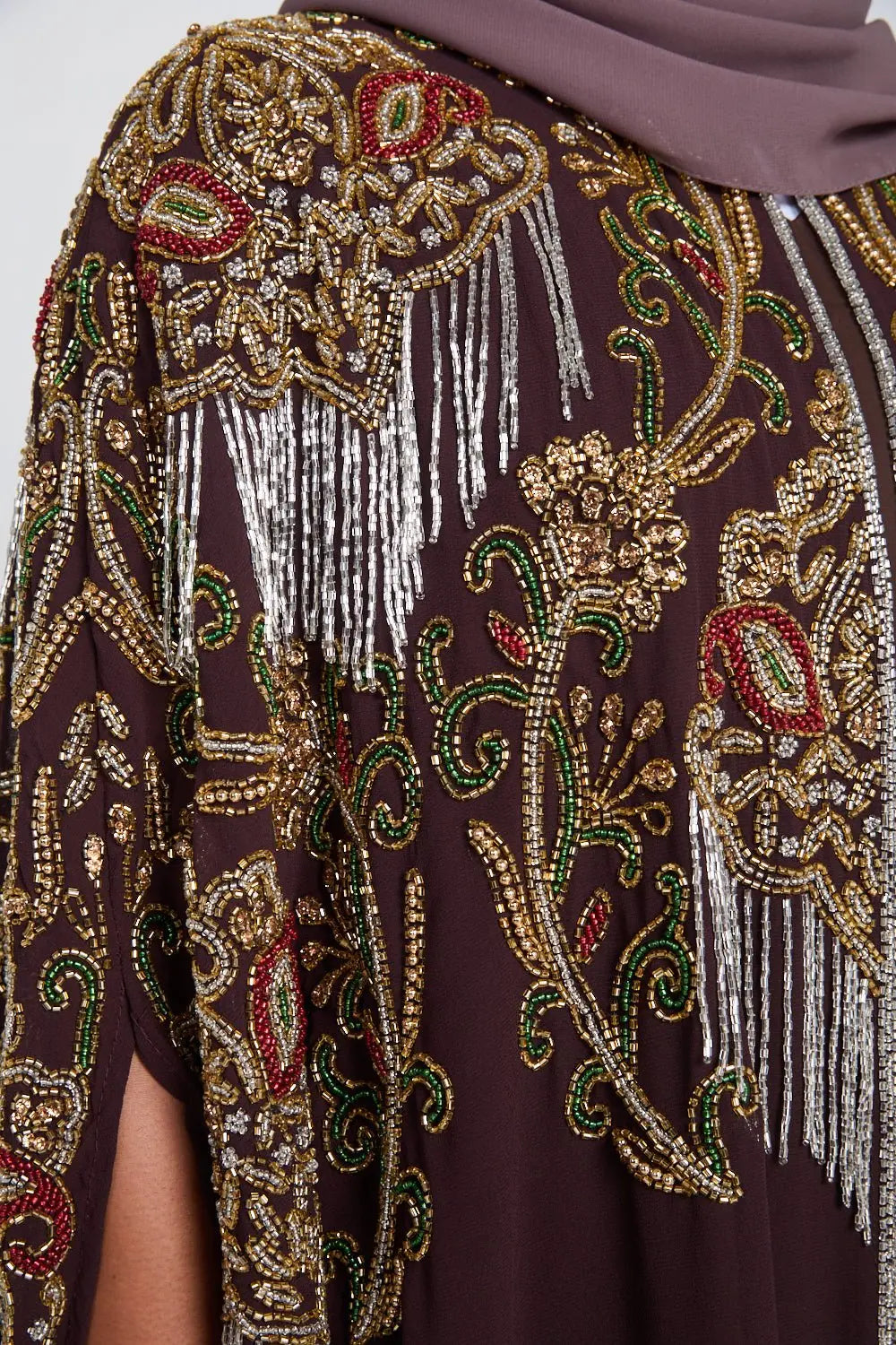 Decorative shawl with intricate beadwork and patterns on a brown background