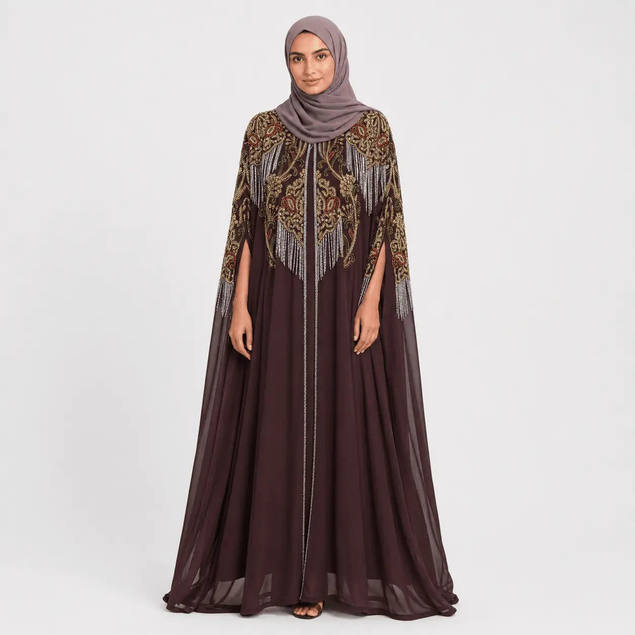 Woman wearing a dark brown dress with intricate patterns and a matching hijab on a white background