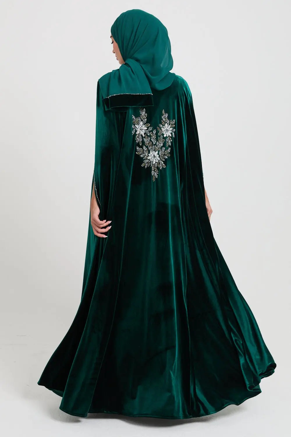 Green velvet dress with floral embroidery on a white background
