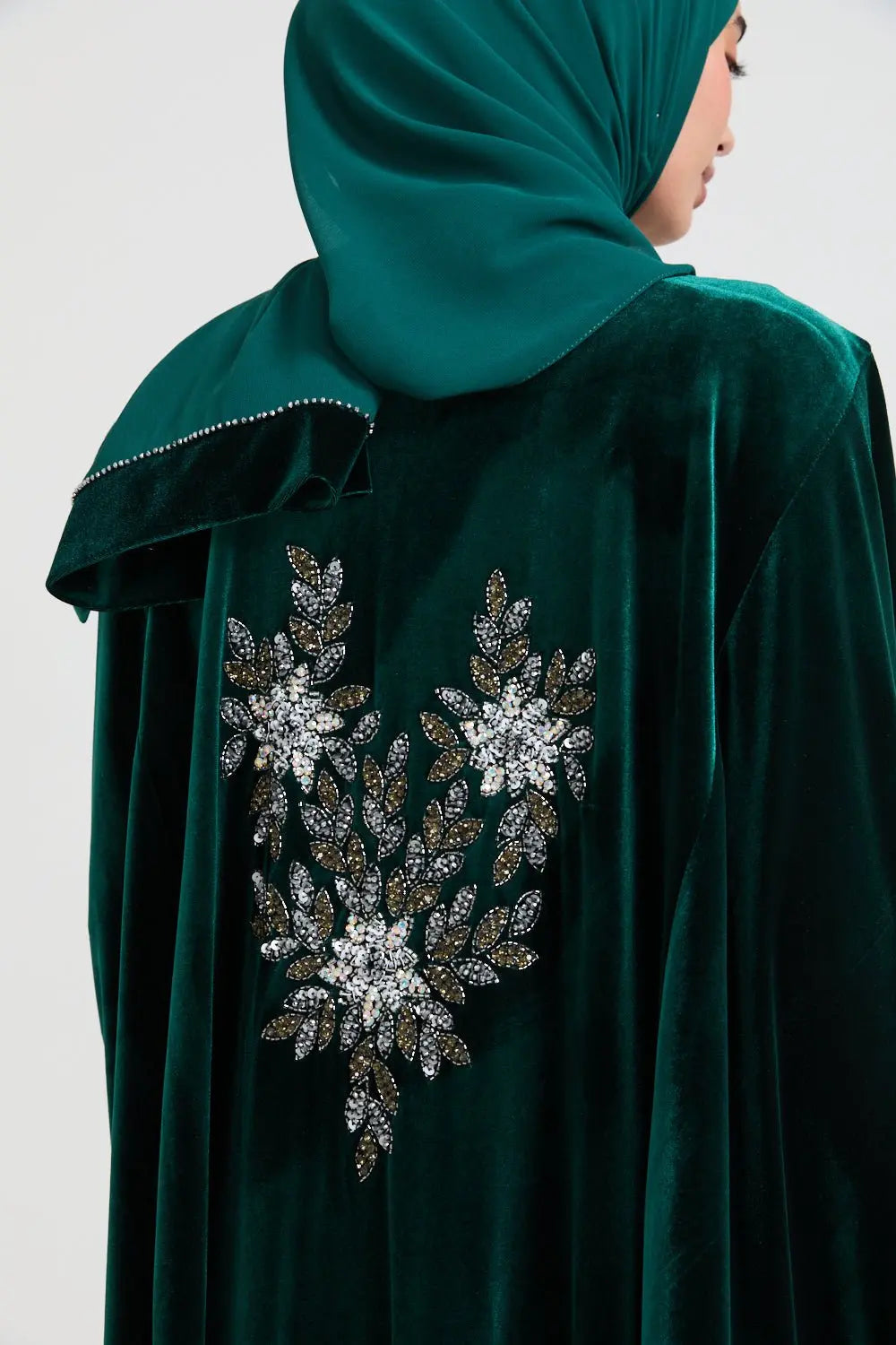 Green abaya with floral embellishments on a plain background