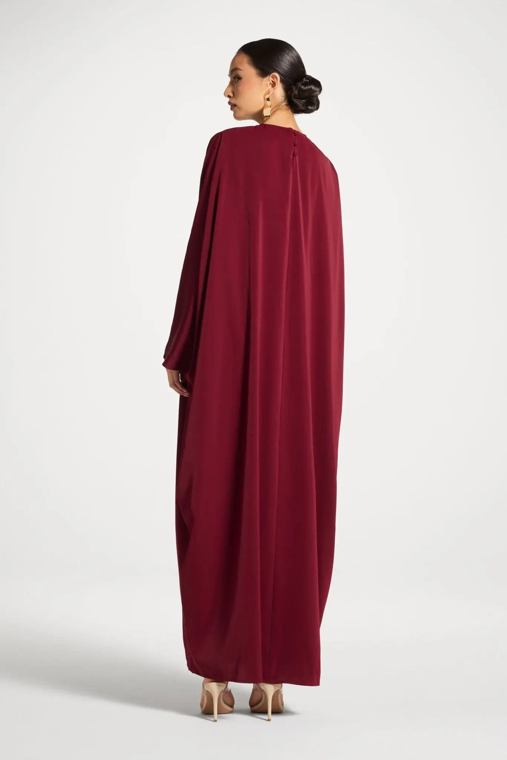 Woman wearing a burgundy dress on a white background