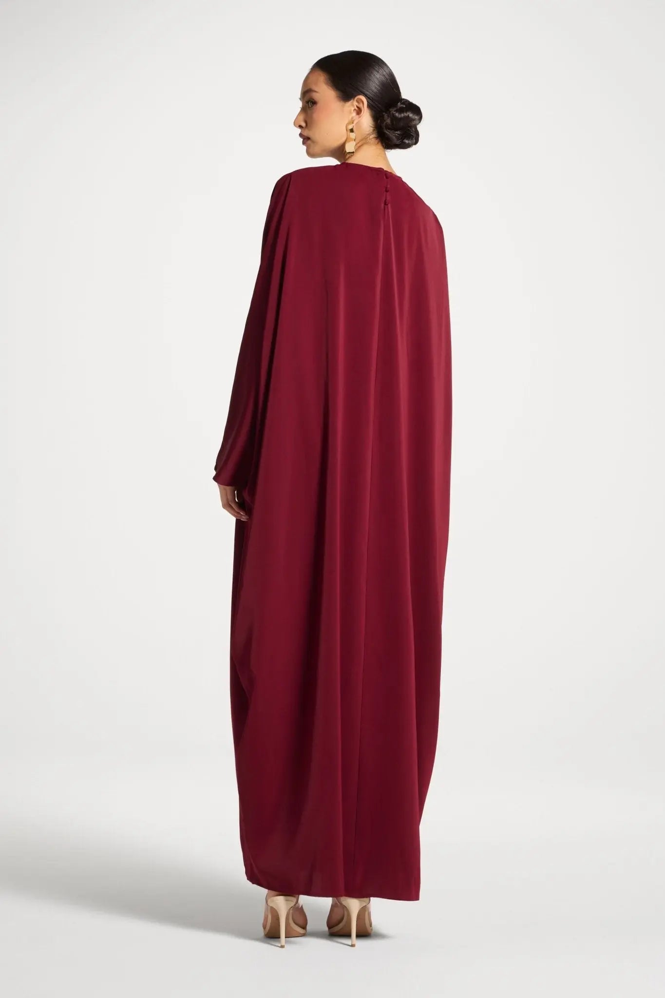 Woman wearing a burgundy dress on a white background