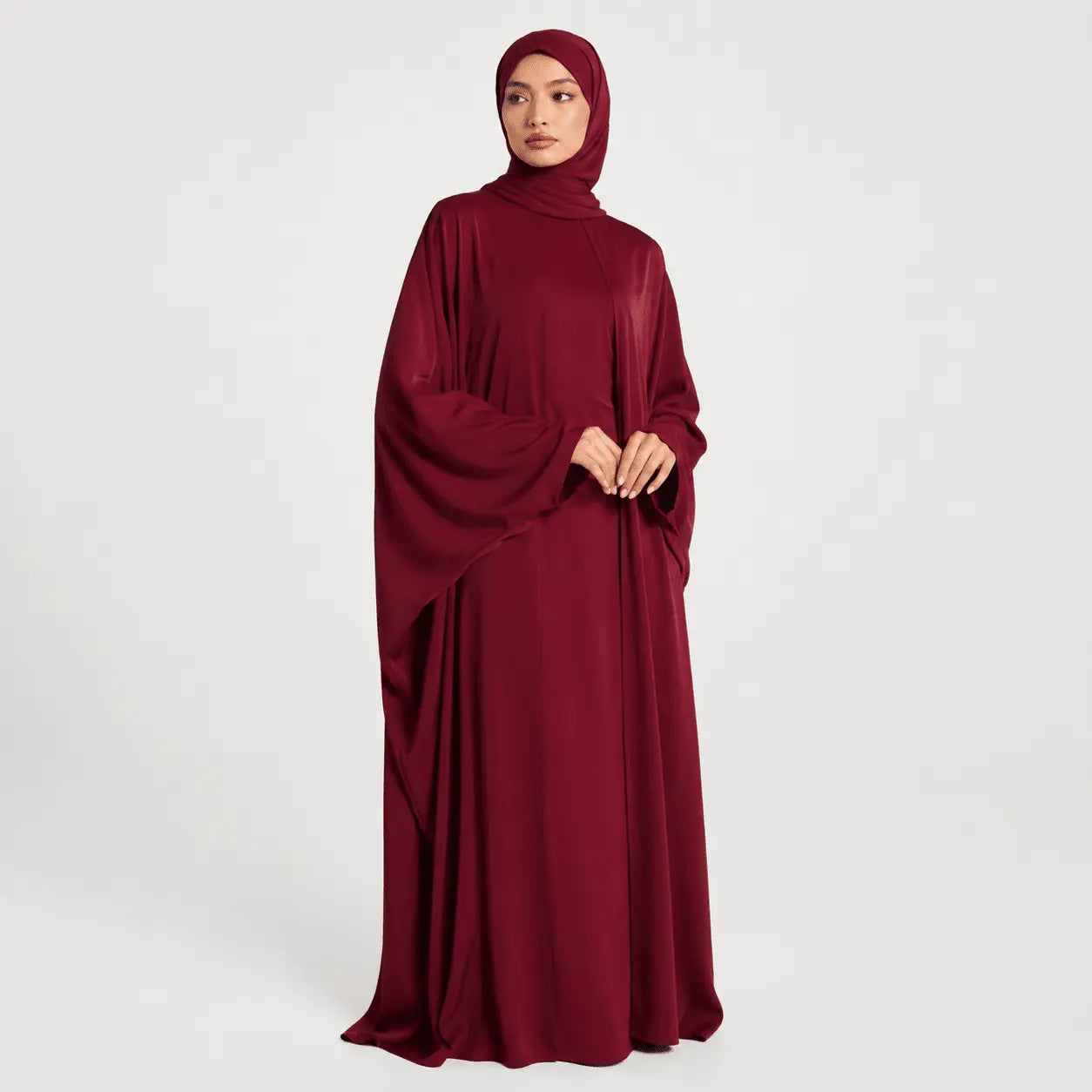 Maroon abaya worn by a model on a white background