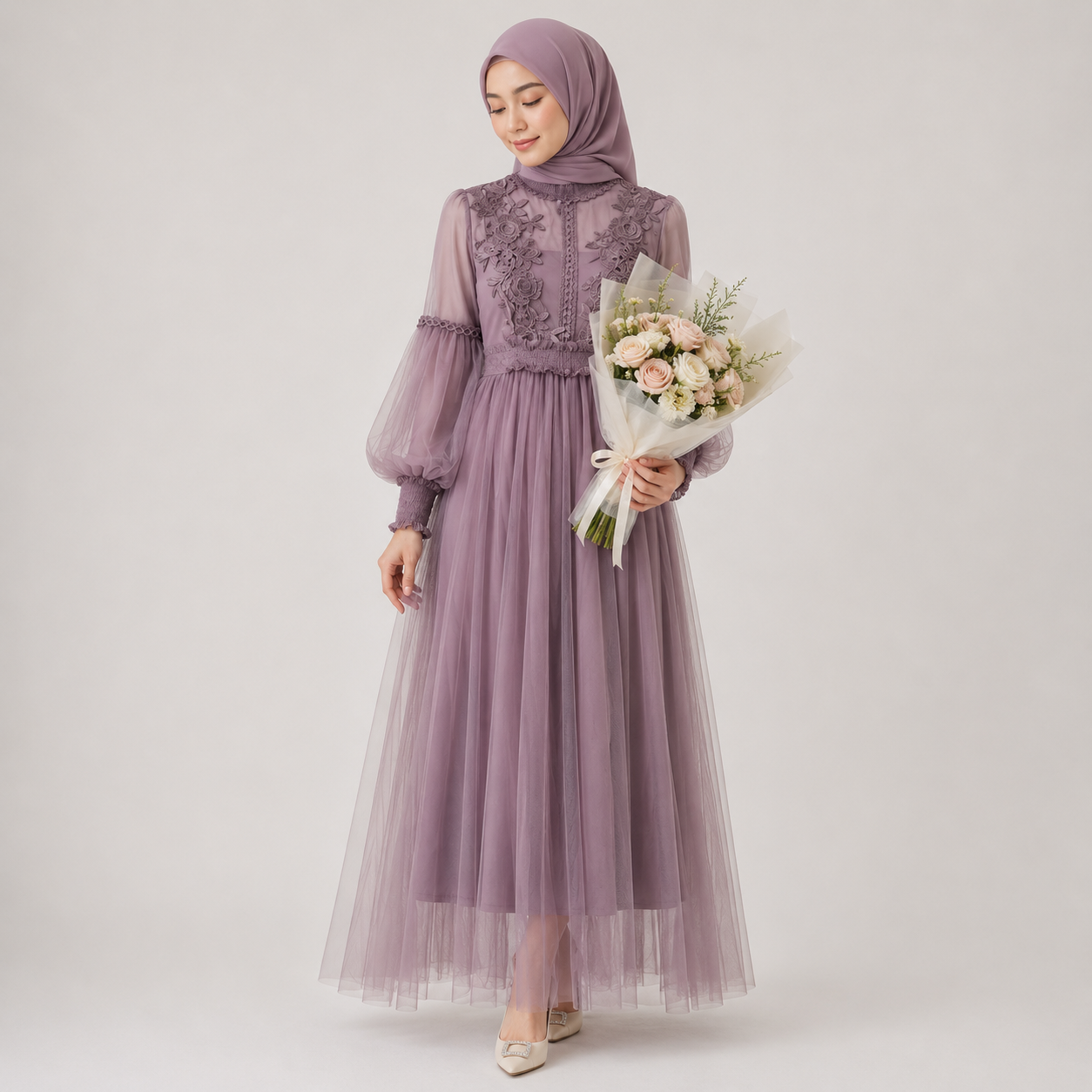 Woman wearing a long purple dress holding a bouquet of flowers on a white background