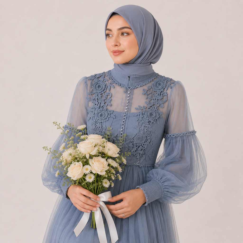 Woman in a blue lace dress holding flowers against a plain background