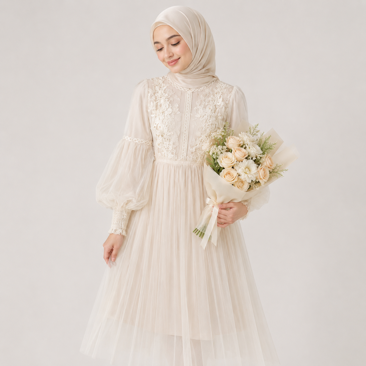Woman in a white dress with floral details holding a bouquet against a light gray background