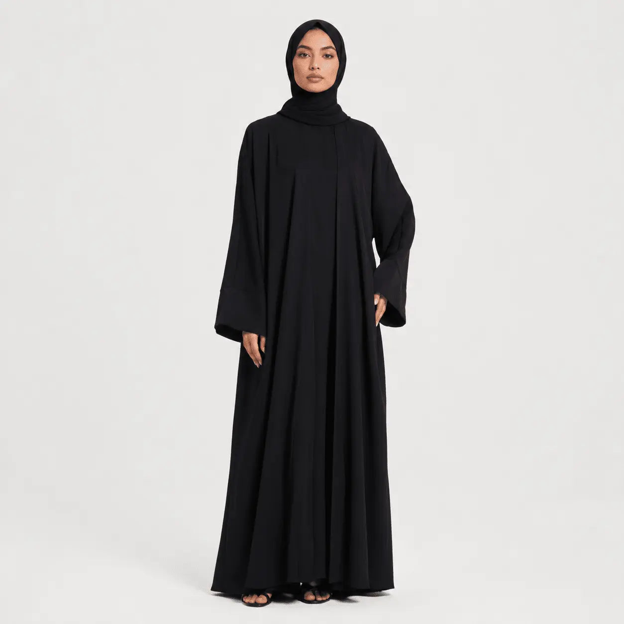 Woman wearing a black abaya on a white background