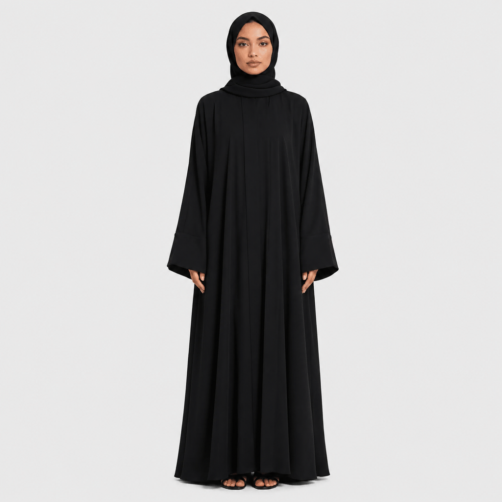 Woman wearing a black abaya on a light gray background