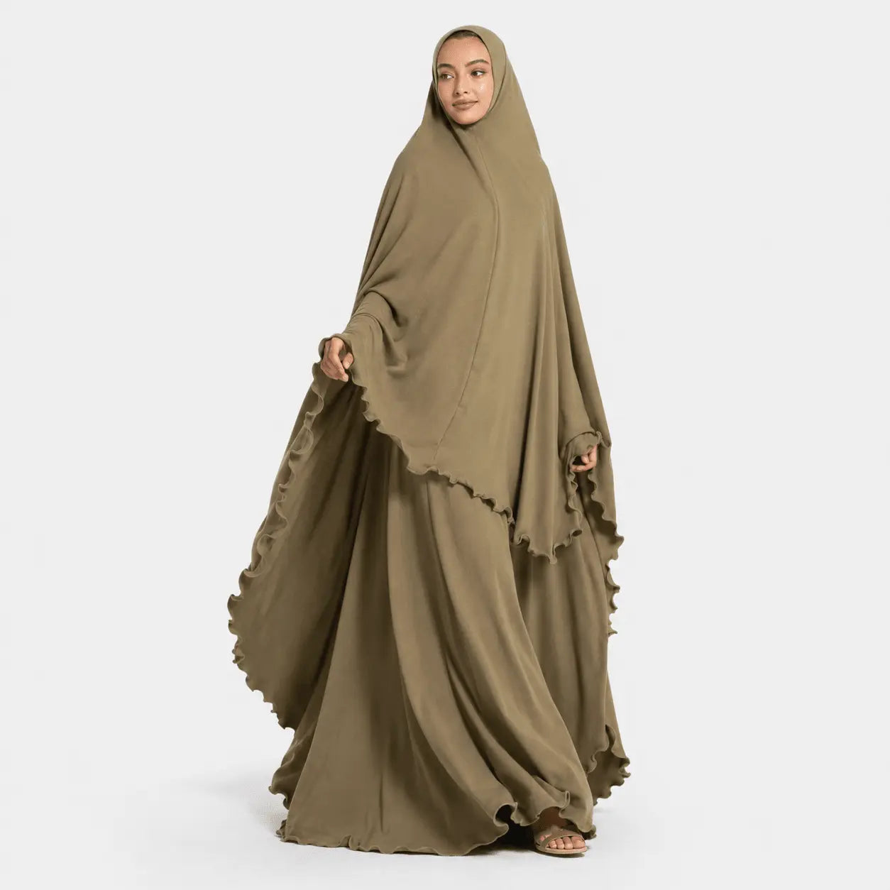 Woman wearing a long, flowing brown dress with a matching hijab on a white background