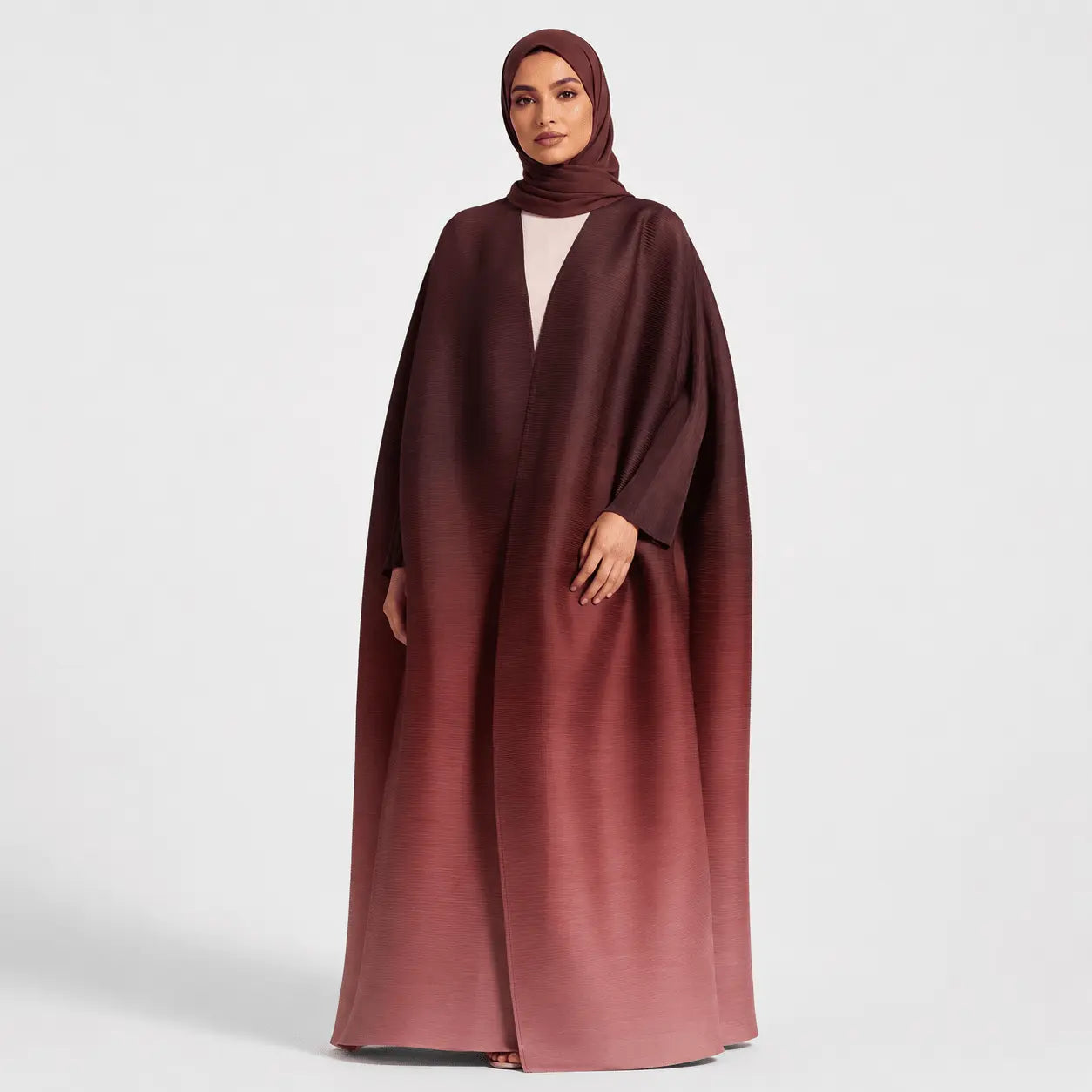 Woman wearing a maroon abaya on a white background