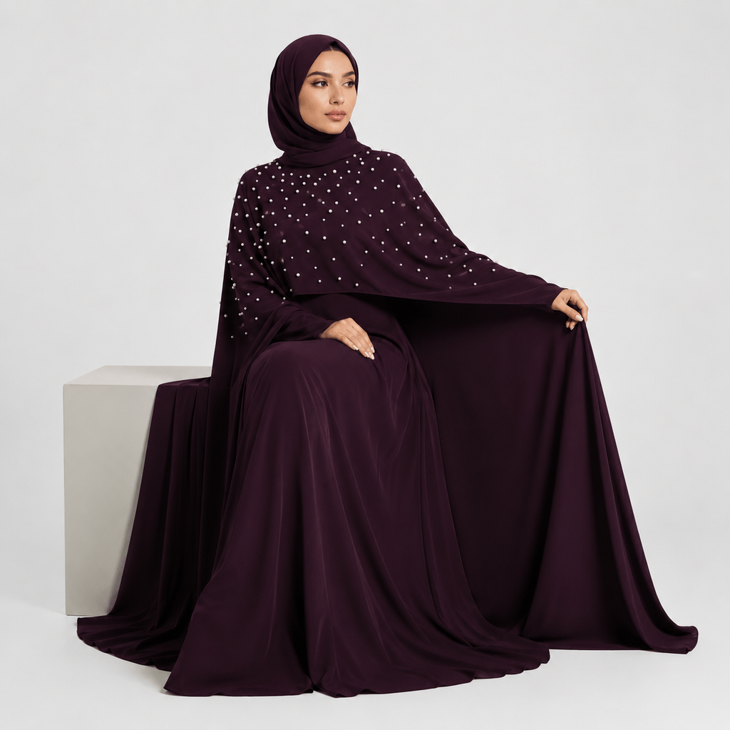 Woman wearing a dark purple abaya with star patterns on a white background