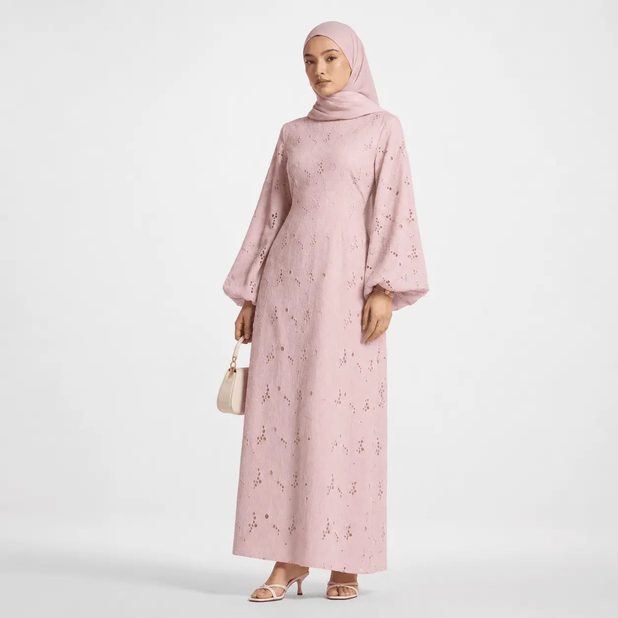 Pink modest long dress with bell sleeves and cutout details, paired with hijab and heels