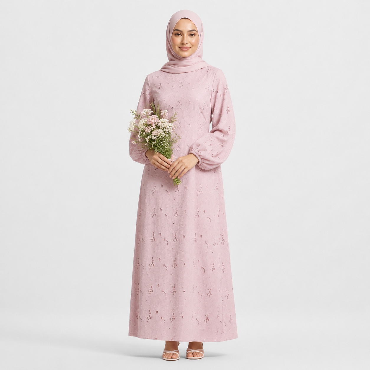 Woman wearing a pink dress with floral patterns on a white background