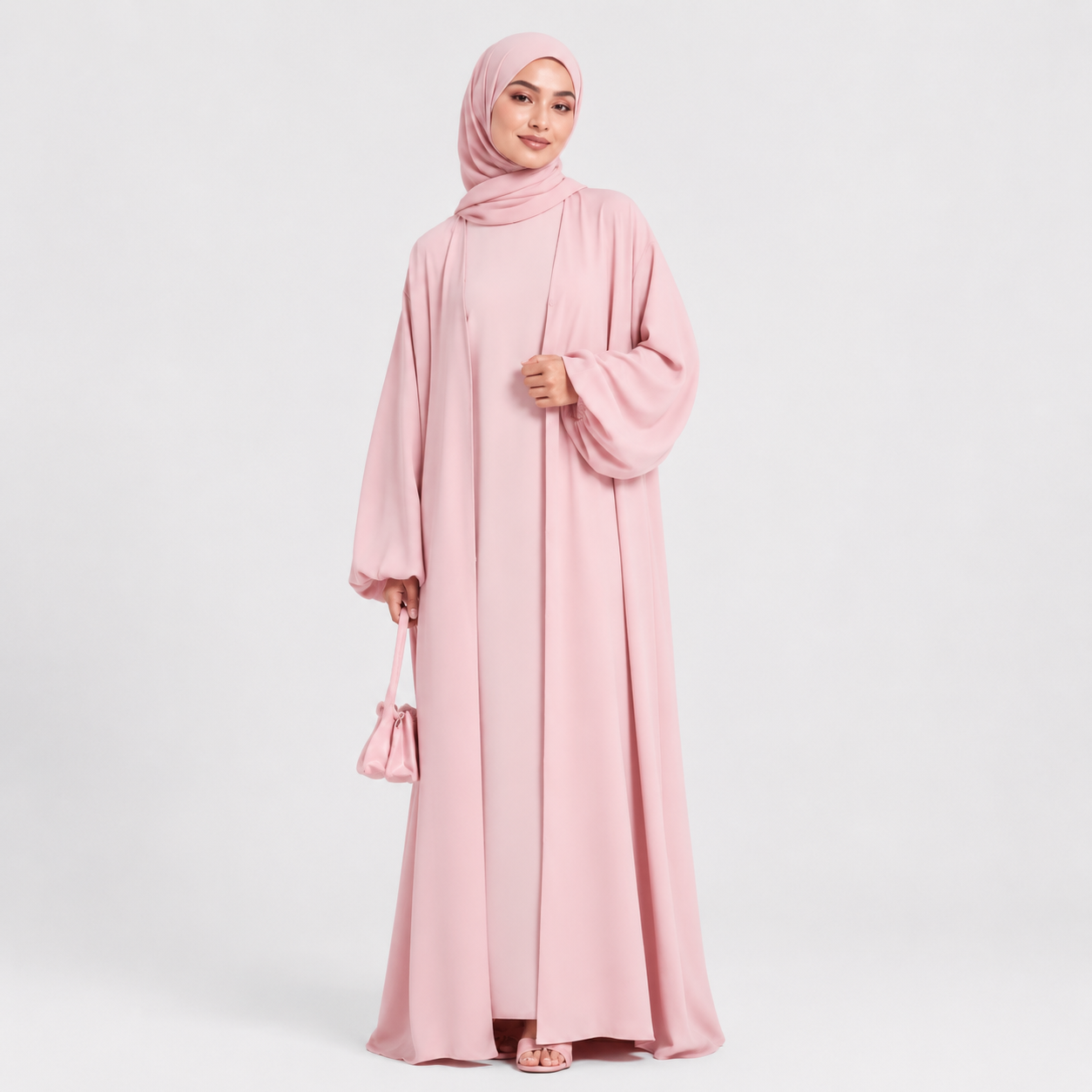 Woman wearing a pink abaya and hijab on a white background
